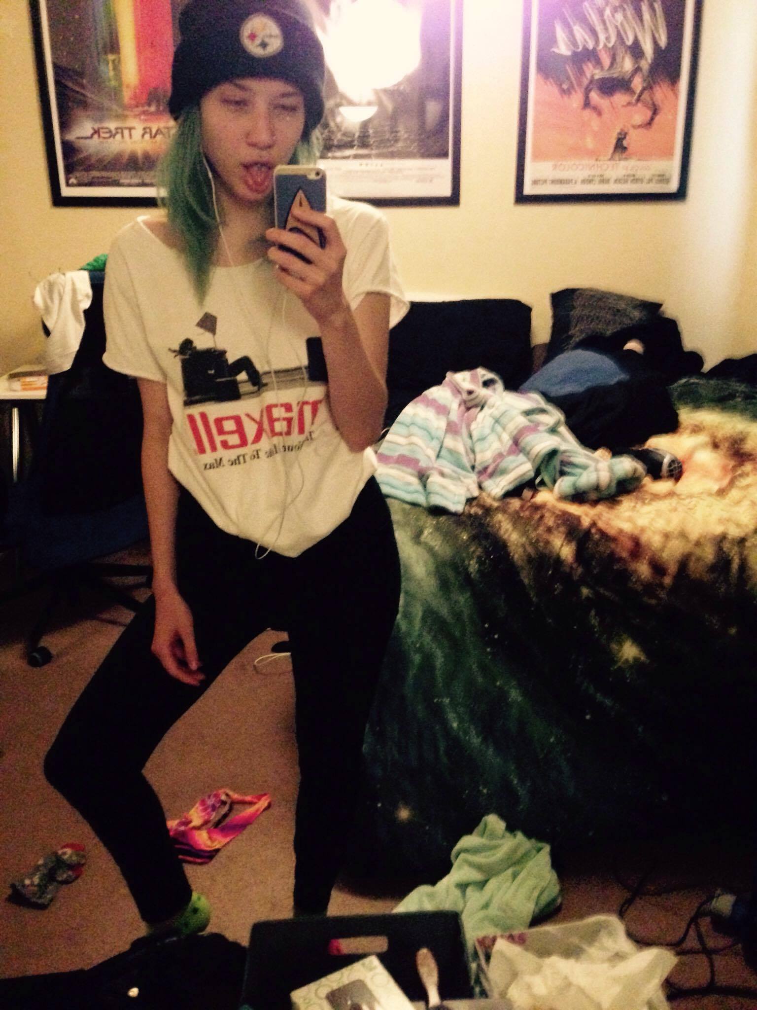 A photo of me with green hair in a very messy room